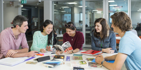 Group of students sitting around a table with books