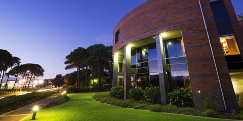 The front of the Curtin Chancellors building, as the sun is setting
