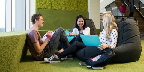 Three students sitting on beanbags talking