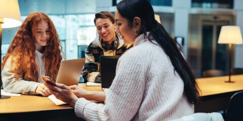 Teenagers working with parent on laptops